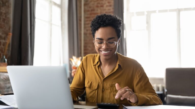 Woman looking at her computer smiling meant to illustrate CPP disability.