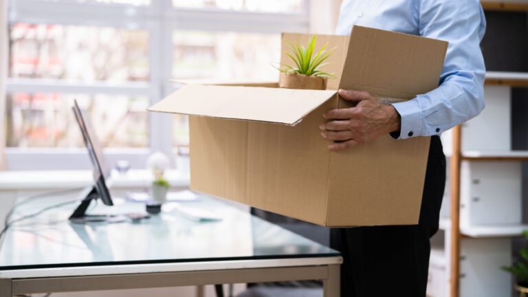 Person holding box of office supplies. Meant to illustrate frustration of contract in Canada.